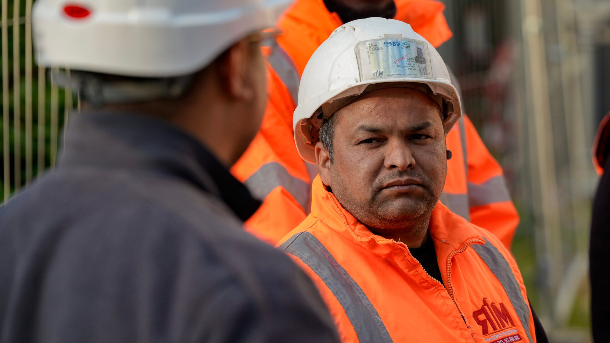Deux compagnons en équipement de sécurité échangent sur un chantier